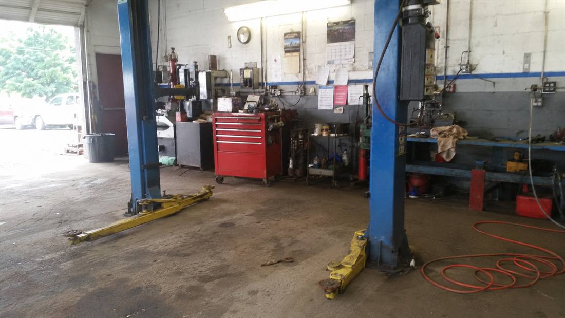 Empty bay in an independent auto repair shop, two-post lift ready